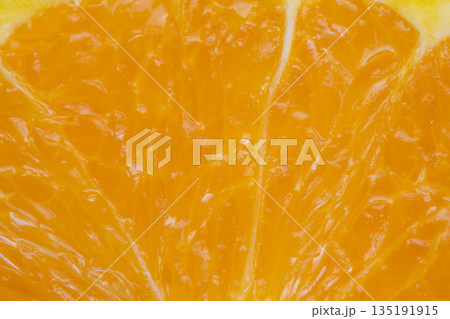 Detailed image of orange wedge emphasizing juicy appeal and color, Intimate shot of citrus slice showcasing juicy pulp and vibrant hue ideal for tropical beverage designs 135191915