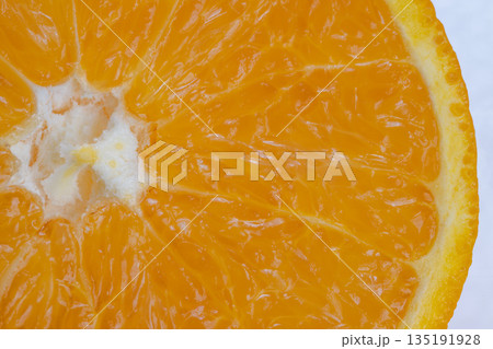 Vibrant fruit interior, Crosssection of citrus revealing nutrients and juicy segments, Close proximity shot highlighting dense juice cells and healthful properties of orange 135191928
