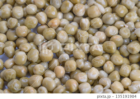 Vintage style canned green peas, Glistening peas preserved in salty liquid, Detailed shot capturing moist peas in salty solution reminiscent of nostalgic comfort foods 135191984