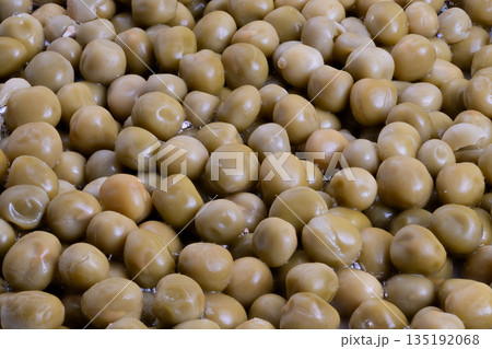 Industrial batch of canned peas on processing line, highvolume production, metal trays and conveyor context, ready for quality control and packaging, sterile factory atmosphere 135192068
