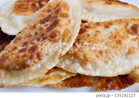Tasty fried snack, Gourmet chebureki presented on simple white dish for starters, Highquality crispy chebureki served on plain white plate suitable for appetizer options Tasty fried snack, Gourmet chebureki presented on simple white dish for starters, Highquality crispy chebureki served on plain white plate suitable for appetizer options 135192127