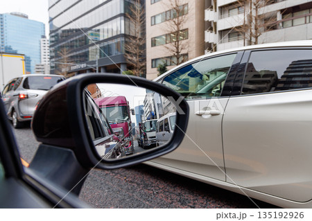 都会の渋滞と街並みを映し出す走行中の車のサイドミラー 都会の渋滞と街並みを映し出す走行中の車のサイドミラー 135192926