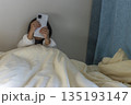 うす暗い部屋で座ってスマートフォンを見る女の子のイメージ（5歳、日本人、顔無し） 135193147