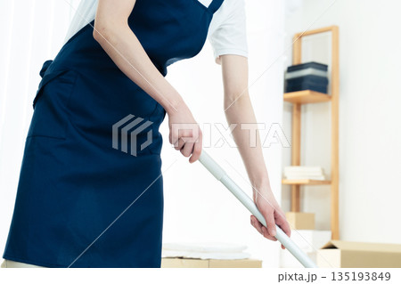 片付けと掃除をする女性 135193849