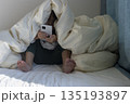 うす暗い部屋で布団をかぶってスマートフォンを見る女の子のイメージ（5歳、日本人、顔無し） 135193897