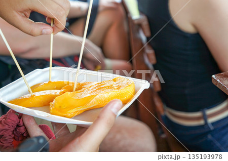 ベトナムの市場で試食した新鮮なマンゴーのかけら ベトナムの市場で試食した新鮮なマンゴーのかけら 135193978