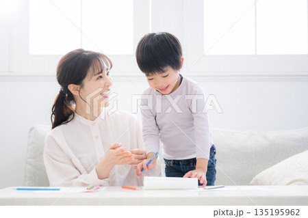 母親（ママ）に見守られながら、ノートを開いて学びを楽しむ幼児　できた！褒める母 135195962