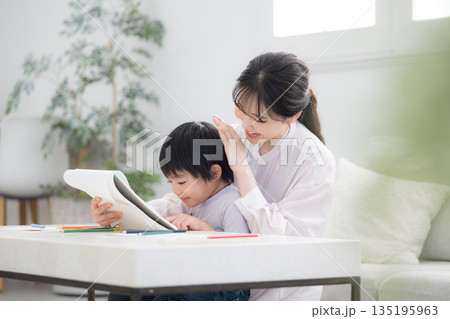母親（ママ）に見守られながら、ノートを開いて学びを楽しむ幼児　子どもを褒める 135195963