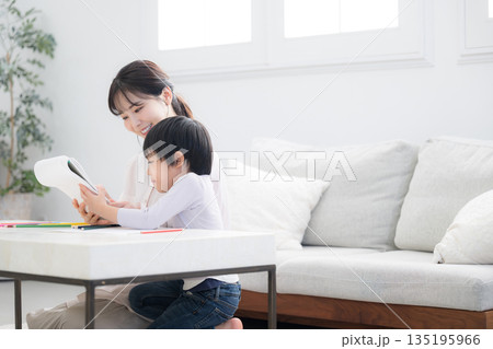 母親(ママ)に見守られながら、ノートを開いて学びを楽しむ幼児 母親(ママ)に見守られながら、ノートを開いて学びを楽しむ幼児 135195966