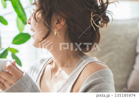 アクセサリー,ピアス,イヤリングをつける女性の横顔 135195974