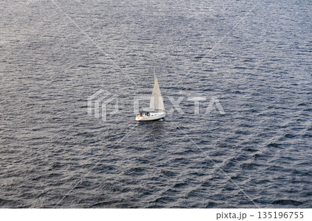 Aerial View of Solitary Sailboat on Expansive Ocean at Dusk 135196755