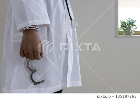 片手に手錠を着けた医者のイメージ（日本人、男性、顔無し、30代） 135197265