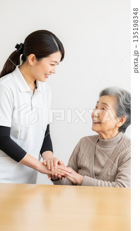 笑顔で手を取る介護士と高齢女性 135198348
