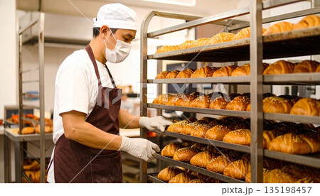 パン工場で働くパン職人 パン工場で働くパン職人 135198457