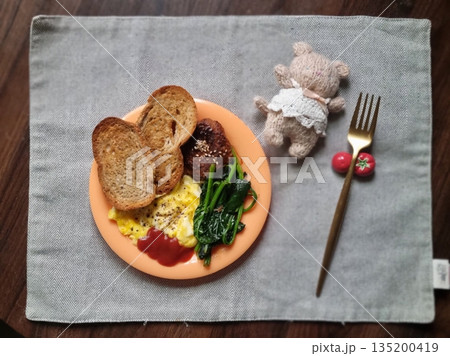 A delightful brunch spread featuring a mix of savory and sweet dishes, including fresh pastries, eggs, seasonal fruits, and a hot beverage. A perfect mid-morning indulgence. 135200419