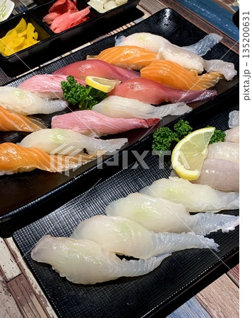 An assortment of fresh sushi, artfully arranged with a variety of toppings and vibrant colors. This traditional Japanese dish combines vinegared rice, seafood, and vegetables for an experience. An assortment of fresh sushi, artfully arranged with a variety of toppings and vibrant colors. This traditional Japanese dish combines vinegared rice, seafood, and vegetables for an experience. 135200631