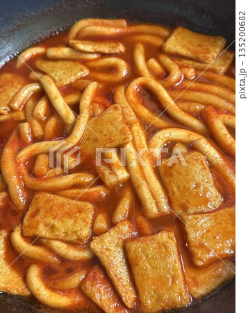 Spicy Korean tteokbokki with chewy rice cakes in a vibrant red sauce, topped with sesame seeds and green onions. A popular street food known for its addictive flavor and satisfying texture. Spicy Korean tteokbokki with chewy rice cakes in a vibrant red sauce, topped with sesame seeds and green onions. A popular street food known for its addictive flavor and satisfying texture. 135200682