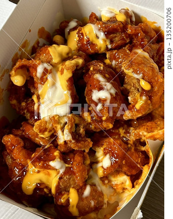 Crispy Korean fried chicken, perfectly glazed with a sweet and spicy sauce. Ideal for food photography and menus, showcasing the irresistible crunch and flavor of this beloved dish. 135200706