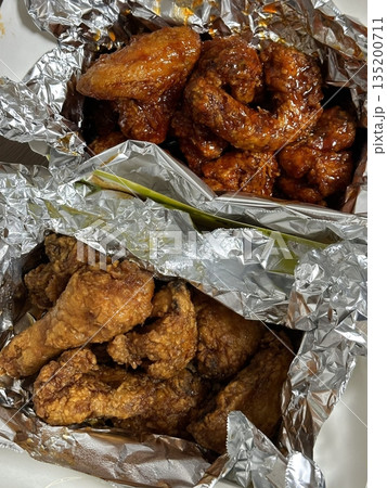 Crispy Korean fried chicken, perfectly glazed with a sweet and spicy sauce. Ideal for food photography and menus, showcasing the irresistible crunch and flavor of this beloved dish. 135200711