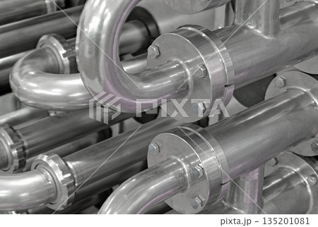 A lot of shiny curved stainless steel pipes of industrial equipment cooling system 135201081