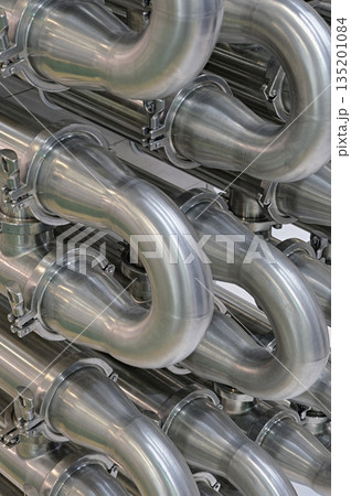 A lot of shiny curved stainless steel pipes of industrial equipment cooling system 135201084