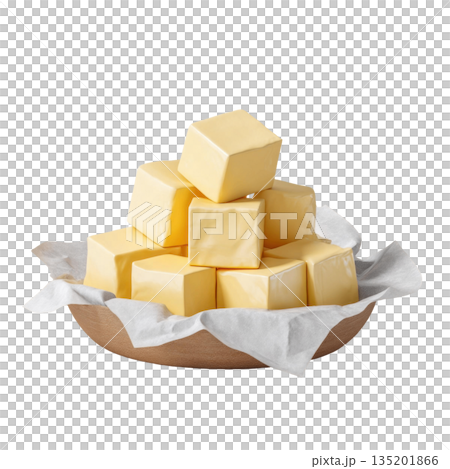 Butter cubes stacked in wooden bowl lined with white parchment paper, showcasing smooth, creamy texture and rich yellow color 135201866