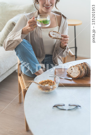 ダイニングテーブルで朝食をとる若いアジア人女性 ダイニングテーブルで朝食をとる若いアジア人女性 135201953