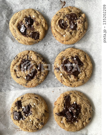 Freshly baked cookies with a golden-brown finish and chocolate chips. Perfectly crisp on the edges with a soft center, offering a delicious, comforting treat for any occasion. 135202209