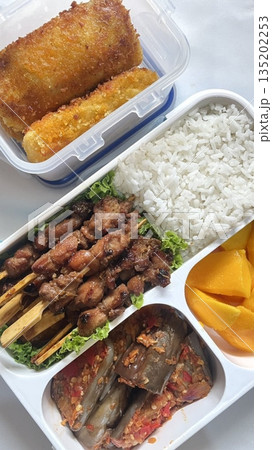A traditional Korean dosirak, beautifully arranged with rice, assorted banchan, and savory proteins. Balanced and visually inviting, it’s a portable meal packed with vibrant flavors. A traditional Korean dosirak, beautifully arranged with rice, assorted banchan, and savory proteins. Balanced and visually inviting, it’s a portable meal packed with vibrant flavors. 135202253