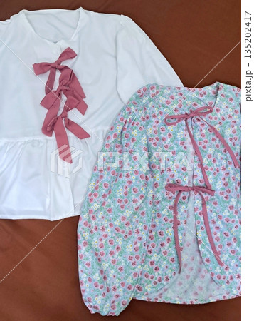 Clothes hanging neatly on hangers under the sun, gently swaying in the breeze—offering a perfect glimpse of fresh laundry days, clean fabric, and simple everyday beauty in every scene. 135202417