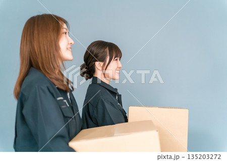 ダンボールを持つ軽作業・運送・物流・宅急便・宅配便・流通・配達・宅配業者の作業員の女性 135203272