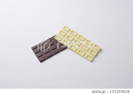 白い背景の板の上に置かれた白と茶色の板チョコ 白い背景の板の上に置かれた白と茶色の板チョコ 135203626