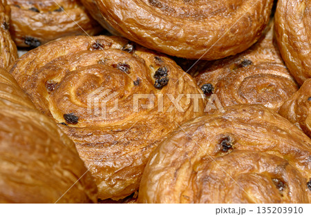 Various types of traditional pastries made from puff pastry - croissants and buns with raisins Various types of traditional pastries made from puff pastry - croissants and buns with raisins 135203910