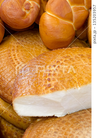 Assorted traditional homemade smoked cheeses on a market stall 135203957