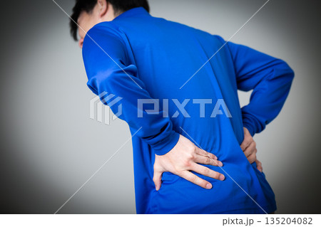 腰痛に苦しむ物流・運送業の青い作業着を着たミドル男性 腰痛に苦しむ物流・運送業の青い作業着を着たミドル男性 135204082