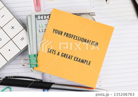 A note stating Your Professionalism Sets A Great Example sits atop United States currency. A calculator and pen rest nearby on an open planner 135206763