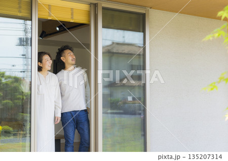 窓辺に立つミドル夫婦 135207314