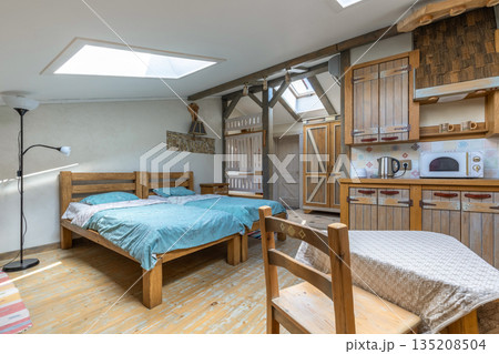 Rustic studio apartment interior with kitchenette and twin beds Rustic studio apartment interior with kitchenette and twin beds 135208504