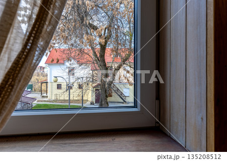 View from the window of a rustic house to a cozy courtyard View from the window of a rustic house to a cozy courtyard 135208512