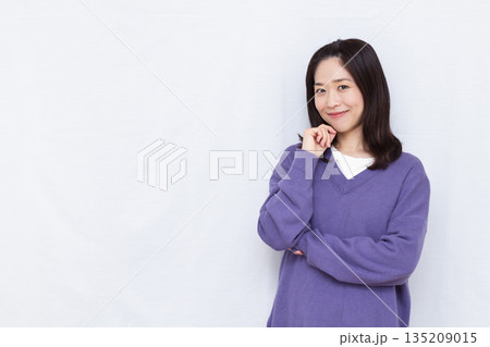 笑顔で考えている女性 135209015