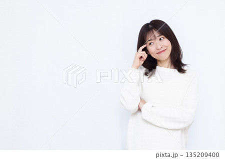頭を抱えて考えている女性 135209400