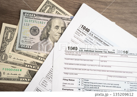 Tax form 1040 U.S. Individual Income Tax Return with dollar banknotes money. 135209612