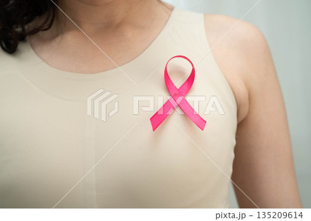 Asian woman with pink ribbon for October world breast cancer day. Asian woman with pink ribbon for October world breast cancer day. 135209614