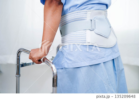 Asian senior pain back wearing elastic support belt with walker. Asian senior pain back wearing elastic support belt with walker. 135209648