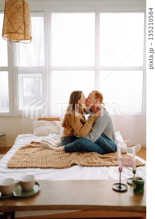 Couple in love relaxing at home on bed while they hug each other. Valentine's Day, holiday concept. Couple in love relaxing at home on bed while they hug each other. Valentine's Day, holiday concept. 135210564