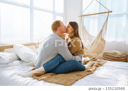 Couple in love relaxing at home on bed while they hug each other. Valentine's Day, holiday concept. 135210568