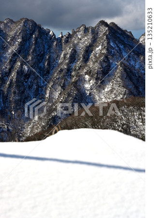 愛鷹山塊の越前岳　北白ガレンの雪庇の先に聳える厳冬の鋸岳の稜線 135210633