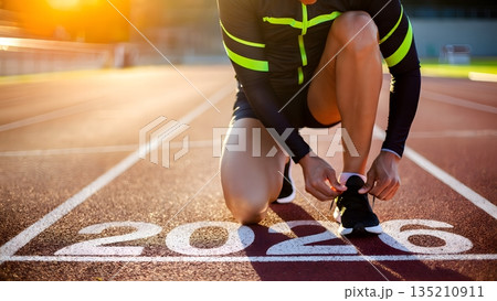 Runner Preparing for Race in Sunset Light on Athletic Track 2026 135210911
