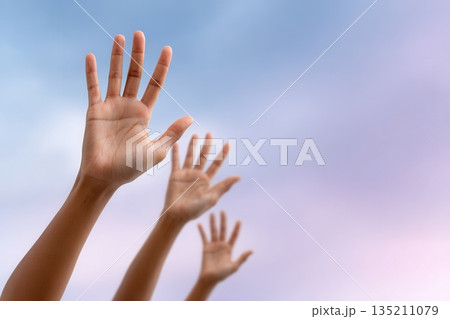 Hands Reaching Upward Against a Colorful Sky Hands Reaching Upward Against a Colorful Sky 135211079