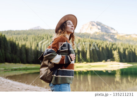 Adventure woman feeling happy among amazing mountains, forest and lake, enjoy the nature landscape Adventure woman feeling happy among amazing mountains, forest and lake, enjoy the nature landscape 135211231